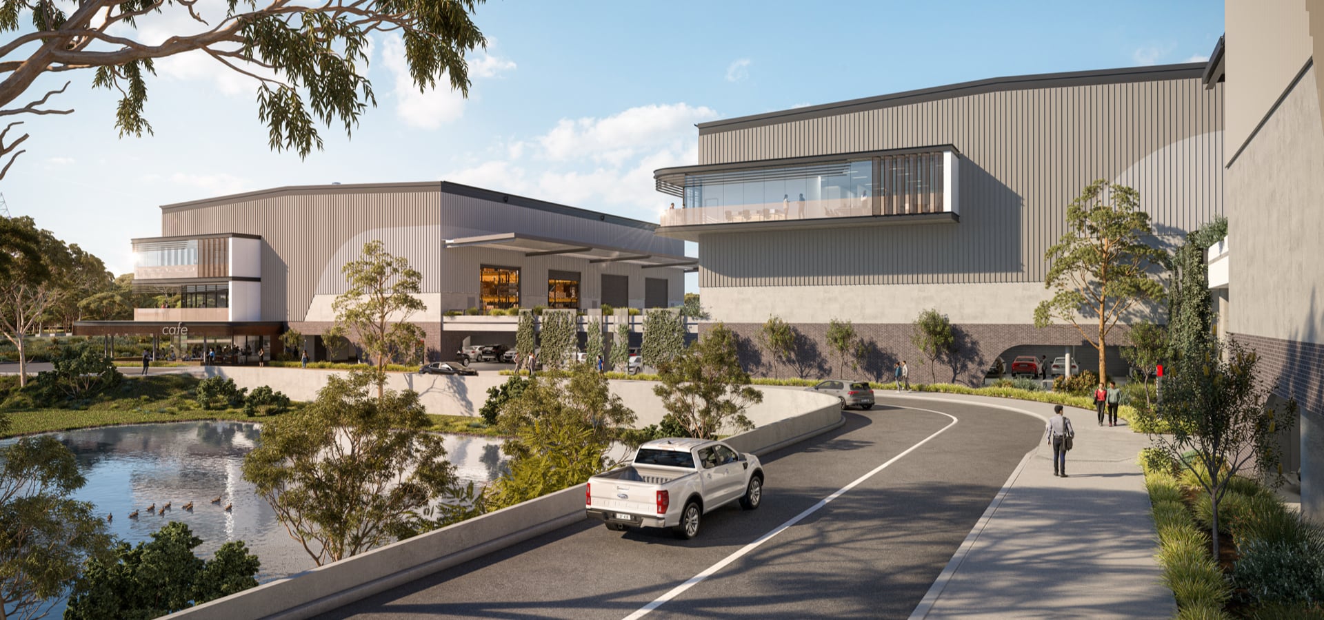 A car driving on a road next to an industrial building.