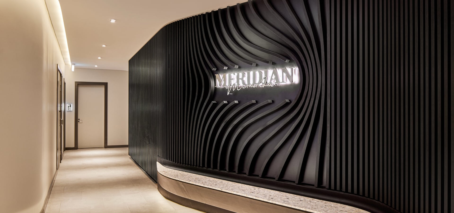 A black wall with the Meridian logo. 