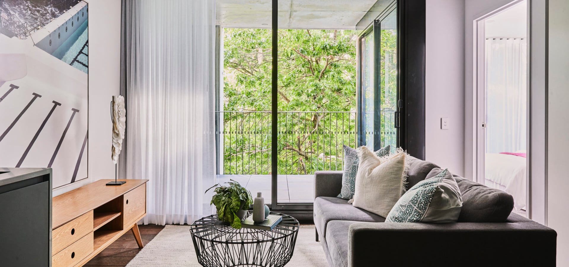 A living room with a couch and a coffee table with an outdoor deck. 