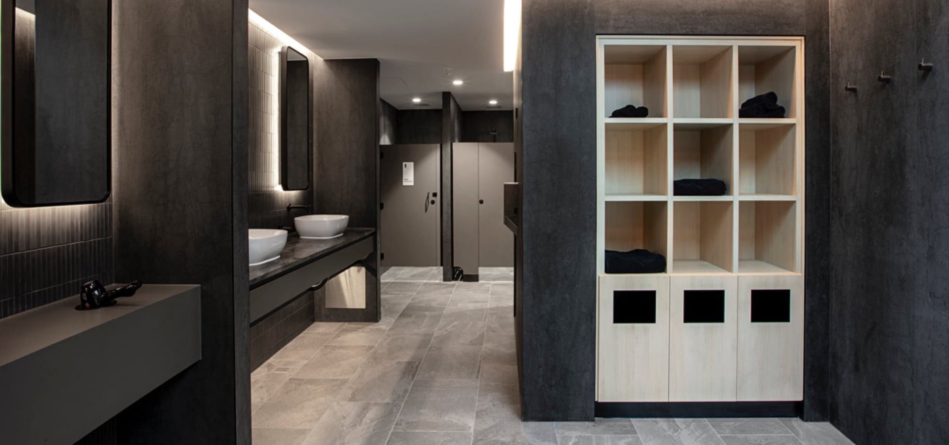 A workout changing room with a sink and shelves.